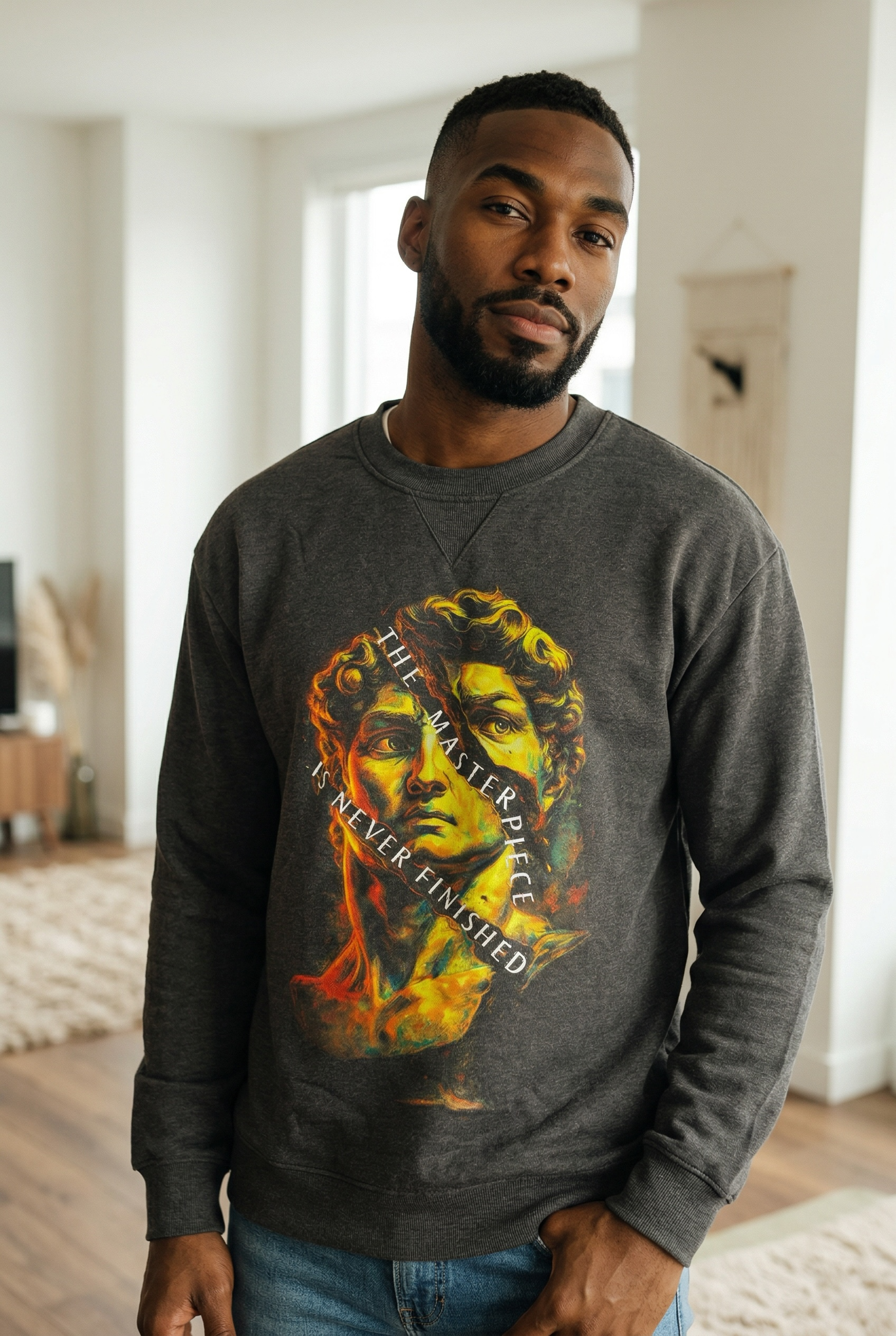 Man wearing a dark gray sweatshirt with a colorful graphic design in a room.